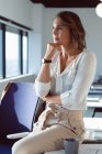 Retrato de mulher de negócios caucasiana pensativa em pé, olhando através da janela. negócio criativo independente em um escritório moderno. — Fotografia de Stock