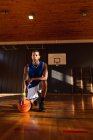 Retrato do jogador de basquetebol afro-americano que segura a bola. basquete, treinamento esportivo em uma quadra interna. — Fotografia de Stock