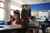 Professeur caucasien enseignant garçon caucasien dans la classe à l'école. concept scolaire et éducatif — Photo de stock