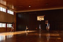 Equipe masculine diversifiée de basket-ball pratiquant le tir avec la balle. basket-ball, entraînement sportif sur un terrain intérieur. — Photo de stock