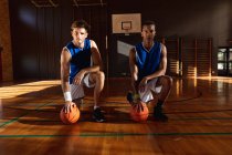 Ritratto di due diversi giocatori di basket maschi che tengono le palle. pallacanestro, allenamento sportivo in un campo coperto. — Foto stock