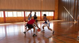 Equipe masculine diversifiée de basket-ball et entraîneur jouant match. basket-ball, entraînement sportif sur un terrain intérieur. — Photo de stock
