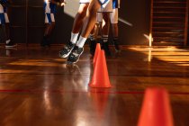 Diverse männliche Basketballteams tragen blaue Sportbekleidung und üben Dribbelball. Basketball, Sporttraining auf einem Indoor-Court. — Stockfoto