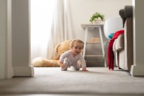 Kaukasisches niedliches Baby, das zu Hause auf dem Boden krabbelt. Mutterschaft, Liebe und Babypflege-Konzept — Stockfoto