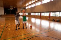 Кавказька жіноча баскетболістка і тренер практикують стрільбу м'ячем. баскетбол, спортивна підготовка при дворі.. — стокове фото