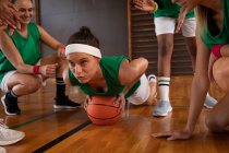 Разнообразная женская баскетбольная команда носит спортивную одежду и делает отжимания. баскетбол, спортивные тренировки на крытой площадке. — стоковое фото