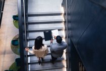 Divers hommes d'affaires et femmes d'affaires discutant ensemble debout dans les escaliers au bureau. concept d'entreprise et de bureau — Photo de stock