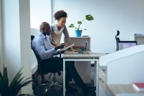 Два разных коллеги по бизнесу мужчины и женщины сидят за столом и пользуются ноутбуком. работа в независимом креативном бизнесе. — стоковое фото