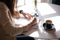 Розрив кавказької жінки-клієнта, що сидить за столом з кавою, робить нотатки. малий незалежний кав'ярня бізнес . — стокове фото