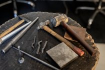 Primo piano di diversi strumenti gioielleria sdraiato sul tavolo in officina. artigianato artigianale indipendente. — Foto stock
