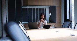 Кавказская деловая женщина с ноутбуком, сидя в конференц-зале в современном офисе. бизнес и офисная концепция — стоковое фото