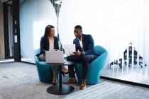 Различные бизнесмен и деловая женщина обсуждают вместе, сидя в современном офисе. бизнес и офисная концепция — стоковое фото