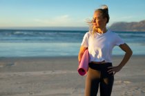 Retrato de mulher caucasiana praticando ioga, de pé na praia e fazendo uma pausa. estilo de vida ativo saudável, fitness ao ar livre e bem-estar. — Fotografia de Stock