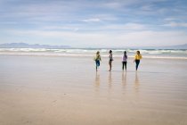 Fröhliche Gruppe unterschiedlicher Freundinnen, die Spaß haben, am Strand spazieren gehen und lachen. Urlaub, Freiheit und Freizeit im Freien. — Stockfoto