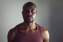 Retrato del hombre afroamericano en forma haciendo ejercicio en el gimnasio, mirando directamente a la cámara. estilo de vida activo saludable, entrenamiento cruzado para fitness. - foto de stock
