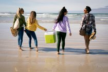 Fröhliche Gruppe unterschiedlicher Freundinnen, die sich amüsieren und lachend am Strand entlang spazieren. Urlaub, Freiheit und Freizeit im Freien. — Stockfoto