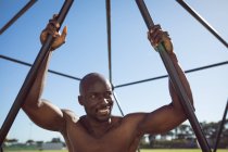 Portrait of african american muscular man on exercise frame outdoors. healthy active lifestyle, cross training for fitness. — Stock Photo