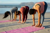 Gruppe verschiedener Freundinnen, die Yoga praktizieren und am Strand meditieren. gesunder aktiver Lebensstil, Fitness und Wohlbefinden im Freien. — Stockfoto