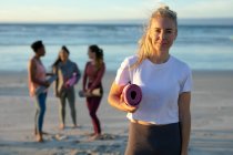 Portrait of caucasian woman practicing yoga, standing at the beach taking break. healthy active lifestyle, outdoor fitness and wellbeing. — Stock Photo