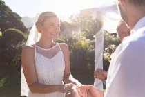 Glückliche kaukasische Braut und Bräutigam beim Eheversprechen Händchen haltend. Sommerhochzeit, Ehe, Liebe und Festkonzept. — Stockfoto