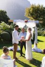 Noiva caucasiana feliz e noivo se casar de mãos dadas jurando. casamento de verão, casamento, amor e celebração conceito. — Fotografia de Stock