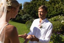 Heureuse mariée caucasienne et marié se marier en se tenant par la main jurant. mariage d'été, mariage, amour et concept de célébration. — Photo de stock