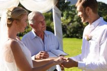 Щаслива біла наречена і наречена одружуються, тримаючи за руки клятву. концепція літнього весілля, шлюбу, любові та святкування . — стокове фото