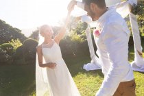 Happy caucasian bride and groom getting married and dancing. summer wedding, marriage, love and celebration concept. — Stock Photo