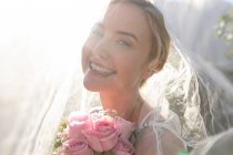 Ritratto di felice sposa caucasica che si sposa con dei fiori in mano. matrimonio estivo, matrimonio, amore e concetto di celebrazione. — Foto stock