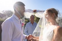 Щаслива біла наречена і наречена одружуються, тримаючи за руки клятву. концепція літнього весілля, шлюбу, любові та святкування . — стокове фото