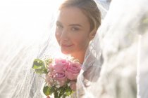 Retrato de noiva caucasiana feliz se casar segurando flores. casamento de verão, casamento, amor e celebração conceito. — Fotografia de Stock