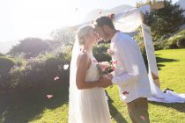 Felici sposi caucasici che si sposano toccandosi la fronte. matrimonio estivo, matrimonio, amore e concetto di celebrazione. — Foto stock