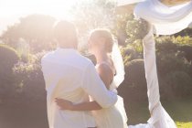 Happy caucasian bride and groom getting married and embracing. summer wedding, marriage, love and celebration concept. — Stock Photo