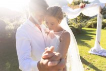 Счастливая кавказская невеста и жених женятся и держатся за руки. летняя свадьба, свадьба, любовь и праздник. — стоковое фото
