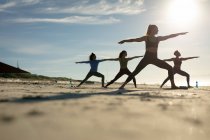 Groupe d'amies diverses pratiquant le yoga à la plage. mode de vie actif sain, fitness en plein air et bien-être. — Photo de stock