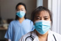 Портрет двох азіатських лікарів, які носять маски для обличчя вдома. медико фізіотерапевтичне лікування . — стокове фото
