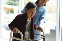 Asian female physiotherapist treating senior female patient at her home. healthcare and medical physiotherapy treatment. — Stock Photo
