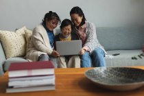 Felice anziana donna asiatica a casa con figlia adulta e nipote utilizzando il computer portatile. stile di vita senior, trascorrere del tempo a casa con la famiglia. — Foto stock