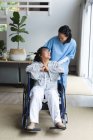 Fisioterapeuta asiática que trata a una paciente asiática en su casa. atención médica y fisioterapia médica tratamiento. - foto de stock