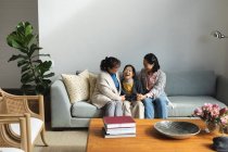 Feliz sênior asiático mulher em casa com adulto filha e neta abraçando. estilo de vida sênior, passar tempo em casa com a família. — Fotografia de Stock