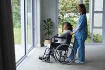 Азійка-жінка фізіотерапевт лікує вдома азіатську жінку-пацієнта. Медичне обслуговування та фізіотерапія. — стокове фото