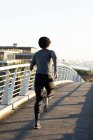 Fit afrikanisch-amerikanischer Mann beim Laufen in der Stadt auf der Straße. Fitness und aktiver urbaner Lebensstil im Freien. — Stockfoto