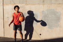 Fit afrikanisch-amerikanischer Mann, der in der Stadt Basketball auf der Straße spielt. Fitness und aktiver urbaner Lebensstil im Freien. — Stockfoto
