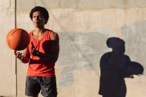 Fit afrikanisch-amerikanischer Mann, der in der Stadt Basketball auf der Straße spielt. Fitness und aktiver urbaner Lebensstil im Freien. — Stockfoto