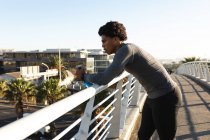 Adatto all'uomo afroamericano che si allena in città riposandosi e bevendo acqua. fitness e stile di vita urbano attivo all'aperto. — Foto stock