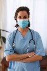 Ritratto di dottoressa caucasica che indossa una maschera facciale e guarda la telecamera. servizi medici e sanitari durante la pandemia di coronavirus covid 19. — Foto stock