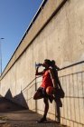 Жирний афроамериканець, який займається фізичними вправами в місті, тримає баскетбол і п'є воду на вулиці. Фітнес і активне вуличне життя. — стокове фото