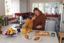 Лесбиянки улыбаются и готовят завтрак на кухне. бытовой образ жизни, свободное время дома. — стоковое фото