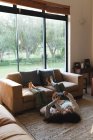 Mère et fille de race mixte couchées sur le tapis, en utilisant un smartphone dans le salon. style de vie domestique et passer du temps de qualité à la maison. — Photo de stock
