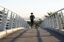 Fit afrikanisch-amerikanischer Mann beim Laufen in der Stadt auf der Straße. Fitness und aktiver urbaner Lebensstil im Freien. — Stockfoto